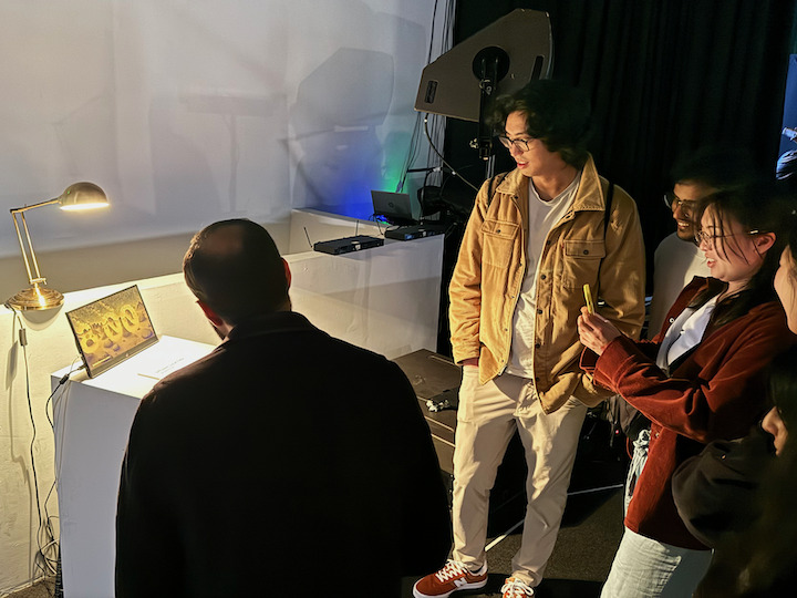 half a dozen people looking at diffusion local time at 8pm, showing a desert landscape with boulders artfully arranged to intimate the numbers 8 and then a slight space and then 0 and 0